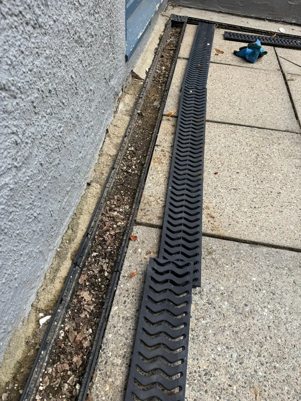 Gully cleaning in King's Lynn with channel drain covers removed to clear built-up leaves, silt and debris.