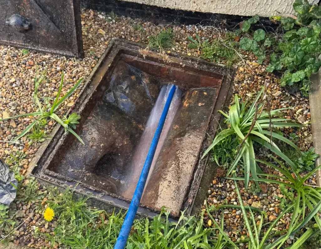 Emergency drain King's Lynn jetting work in progress with a high-pressure hose clearing a residential drainage chamber.