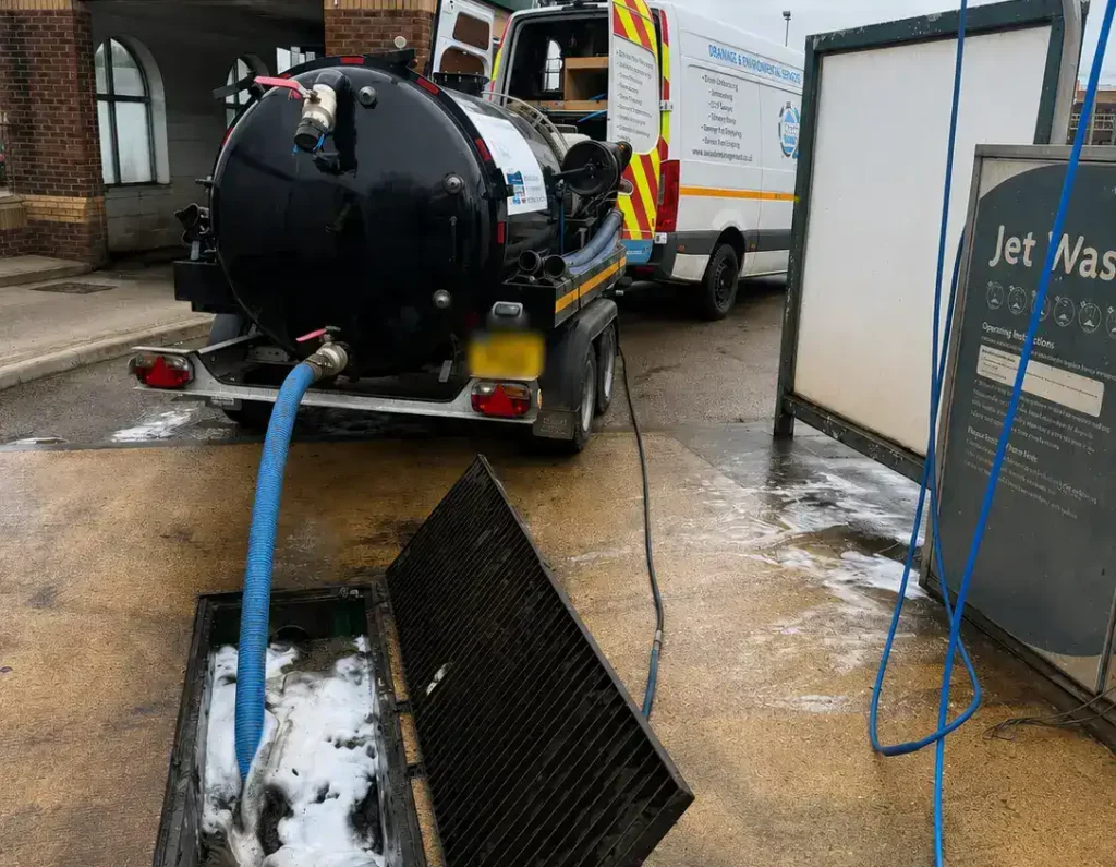 Commercial Drainage King's Lynn forecourt interceptor cleaning by AM Waste Management using a vacuum tanker to clean a commercial car wash interceptor system.