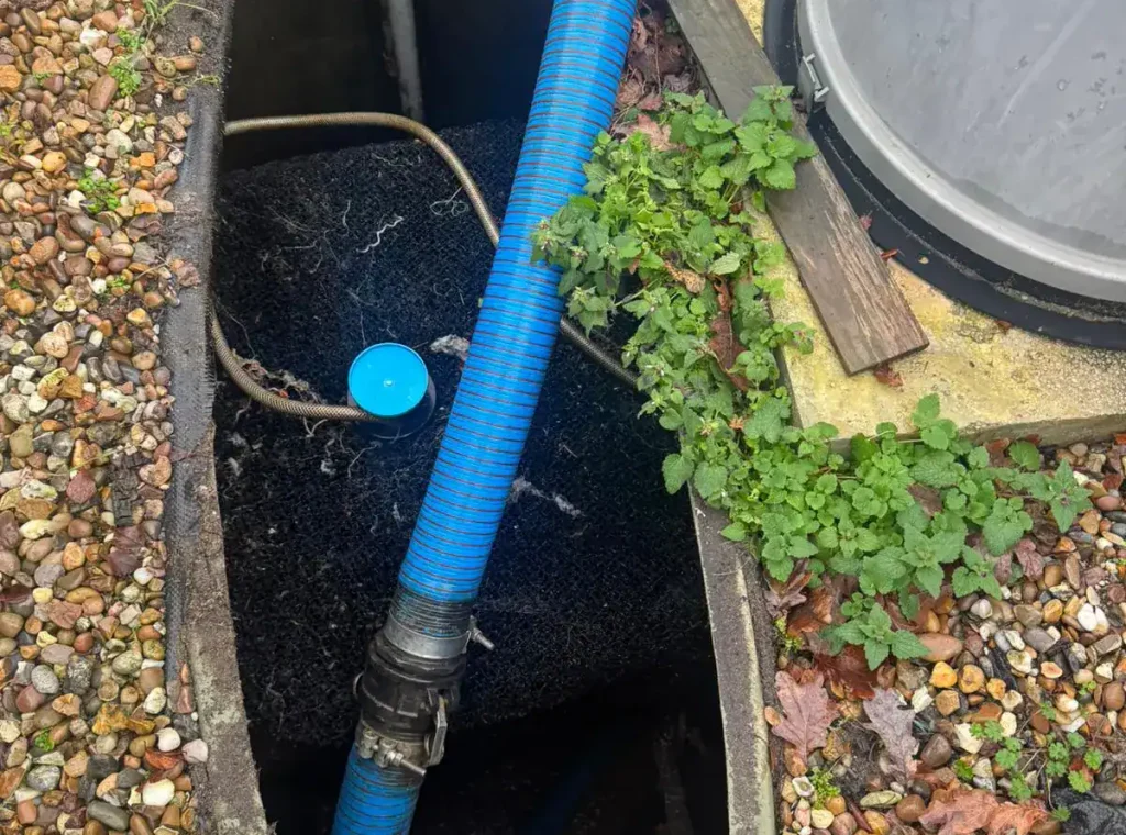 Routine sewage treatment plant servicing with extraction hose connected by AM Waste Management, providing drainage services in King's Lynn and West Norfolk.
